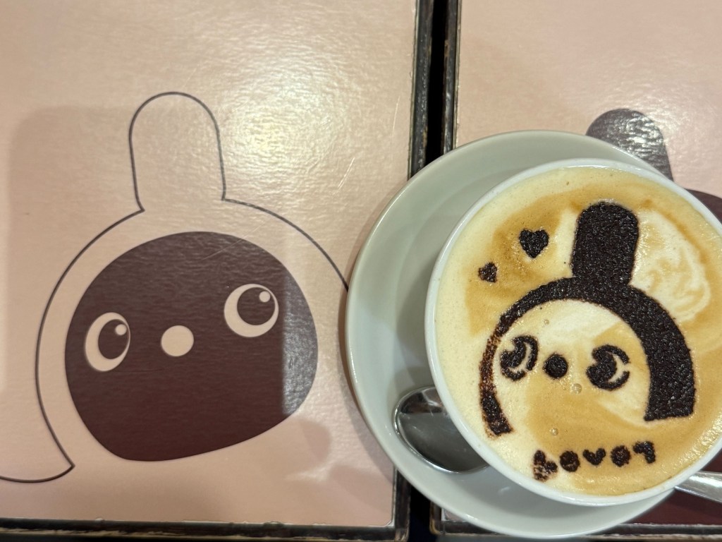 LOVOT カフェで提供されたラテアート。ラテの表面に描かれたLOVOTとテーブルに描かれたLOVOTが並んで写っている。